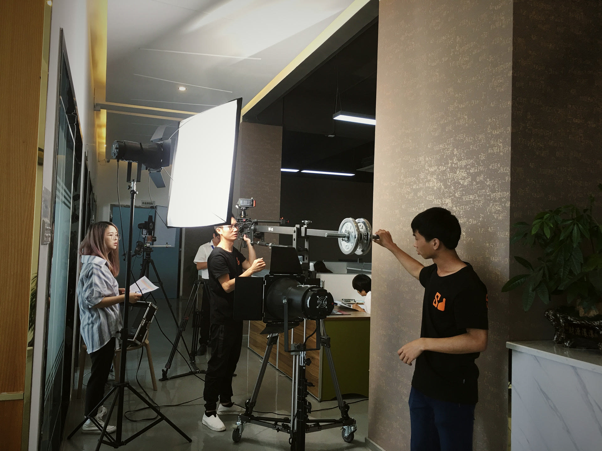 走廊里等布光,客户方拿着稿子对词,摄影师守着机位看回放。